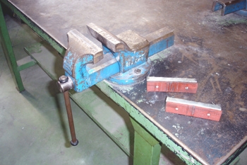 Tornillo de banco antiguo azul montado en un banco de trabajo en un taller  o taller de carpintería dispositivo para sujetar y sujetar objetos y piezas